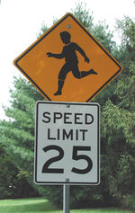 A U.S. warning sign about children in the road, and a speed limit notice