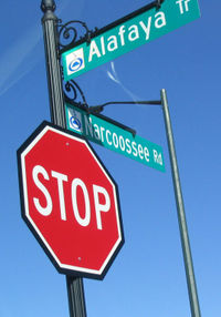 A reflective stop sign with a black background, and two reflective street signs with the Orlando, Florida city logo.