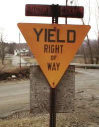 An old embossed yellow yield sign in rural Vermont