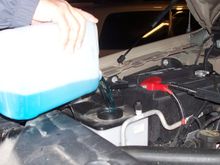 A man pouring antifreeze into his vehicle.