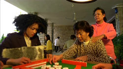 The woman sitting on the left may make a chow with a tile discared by the player on the right.