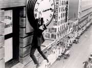 Harold Lloyd hanging from a clock face