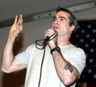 Henry Rollins of Black Flag, displaying hardcore "anti-fashion", wearing simply a plain gray t-shirt.