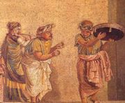 Detail of a mosaic found in Pompeii. The figure on the left is playing the double aulos, double-reed pipes; the figure in the middle, cymbalum, small, bronze cymbals; and on the right, the tympanum, a tambourine-like drum.