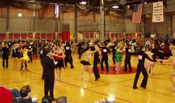 Intermediate level international style latin dancing at the 2006 MIT ballroom dance competition.  A judge stands in the foreground.