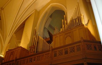 The main portion of the pipe organ at St. Raphael's Cathedral in Dubuque, Iowa.  This organ features an open case design where the pipes are left exposed.  The swell shutters can be seen open in the rear.