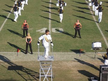 A High School Drum Major takes the podium for a half time performance.